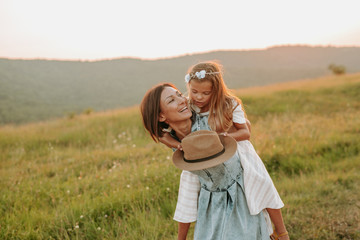 Mom playing with her daughter outdoors in the park.