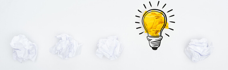 panoramic shot of crumpled paper balls and light bulb illustration on white background, business concept