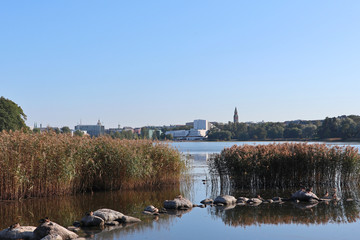 Park with lake with grass stones birds composition in center of european city Finland Helsinki. Nice water nature in city scape
