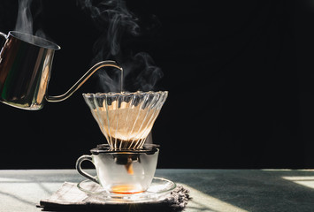 The steam from a cup or a pot of coffee on the old wood table and black background, Warm drinks make good healthy, Drip coffee brew, easy to make at home, Selective focus.
