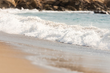 Mediterranean surf. Small waves roll on the shore. Sea foam on the beach.