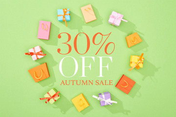 round frame of decorative gift boxes and shopping bags on green background with 30 percent off autumn sale illustration