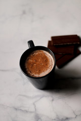 cocoa drink in a blue mug with chocolate on a light background closeup