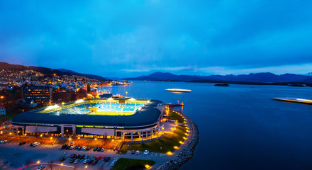 Aerial view of town center in Molde, Norway at night. View of the illuminated stadium