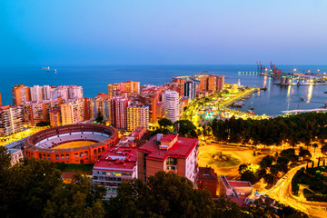 Aerial view of the city center at sunset with bullring arena and mediterranean se in Malaga, Spain