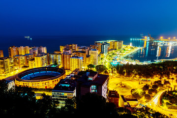 Fototapeta premium Aerial view of the city center at sunset with bullring arena and mediterranean se in Malaga, Spain