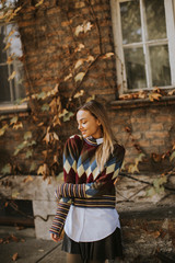 Young woman standing outside at sunny autumn day