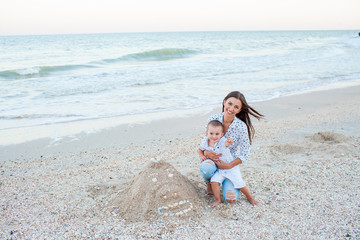 Fototapeta premium Mother and son playing near sea on seashore