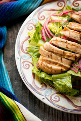 Mexican caesar salad with grilled chicken, romaine lettuce, croutons, dressing, and parmesan cheese. 