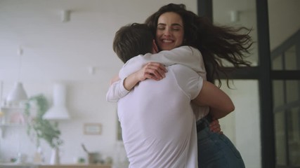 Happy couple hugging at new home. Love couple spinning around