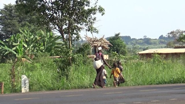 Uganda - August 10th 2016: Ugandan woman with her four children returns home.
