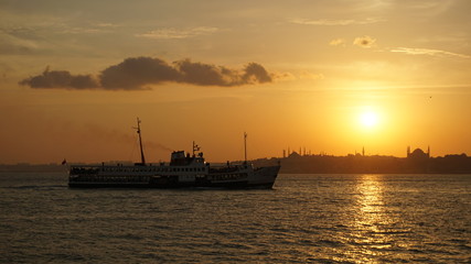 Fototapeta premium The ferry, the sea, and the setting sun