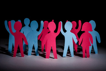 concept of people strike and protest. Paper multi-colored little men with raised hands, on a dark...