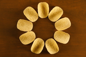 sun or flower shaped potato chips on a brown wooden  table, design for fast food restaurant  menu, copy space for text