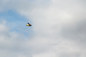Yellow sea plane flying over with clouds