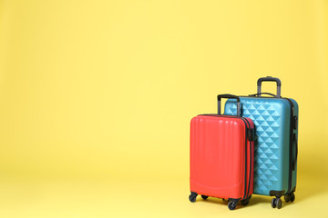 Stylish suitcases on yellow background. Space for text