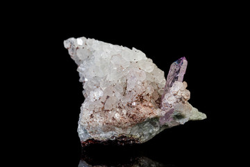 macro mineral amethyst stone in rock on a black background