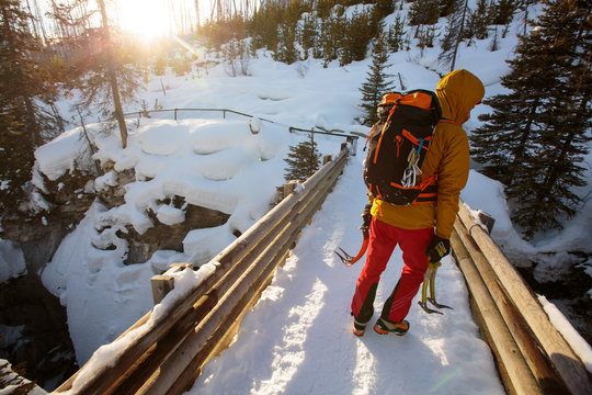 Professional alpine climber Jess Roskelley hikes back to the trailhead after a day of ice climbing at the scenic Marble Canyon, BC in Kootenay National Park near Banff, Alberta amidst the stunning backdrop of the Canadian Rockies.