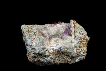 macro mineral amethyst stone in rock on a black background