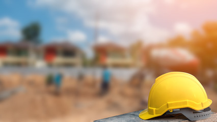 Construction safety concept, yellow hard safety helmet hat in construction site - obrazy, fototapety, plakaty