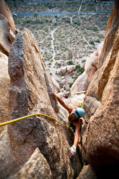 A woman tops out on The Eye 5.3, a classic trad route on Cyclops Rock near the Hidden Valley Campground in Joshua Tree National Park.