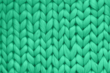 Fototapeta premium Texture of green wool big knit blanket. Large knitting. Plaid merino wool. Top view