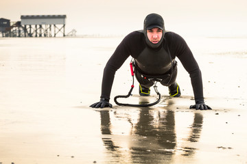 Kiteboarder getting himself warmed up for the last session of the day in the beautiful late-afternoon light in St. Peter Ording, Germany.