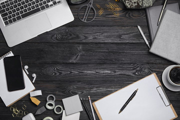 Flat lay composition with laptop. smartphone and stationery on black wooden table, space for text. Designer's workplace - Powered by Adobe