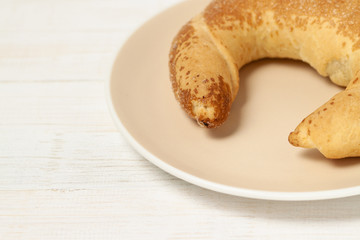 Croissant with ceramic plate wooden wood light background white corner view