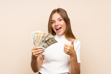 Young blonde woman over isolated background taking a lot of money