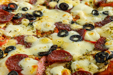 Pizza background. Pizza with sausage and other ingredients close up close up.