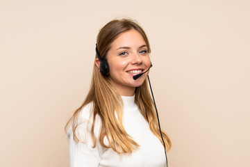 Young blonde woman over isolated background working with headset