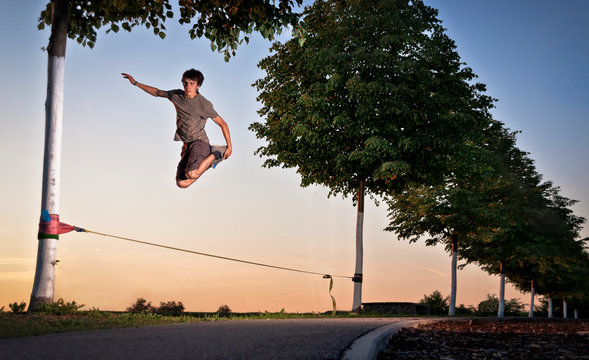 A man jumping on the slackline during sunset in Ditzingen, Germany.