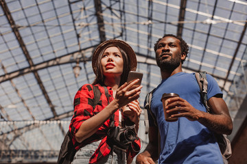 low angle view of woman using smartphone with man looking away