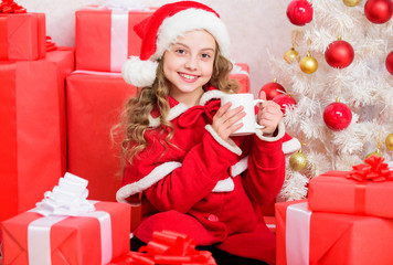 Obraz na płótnie Canvas Kid santa hat enjoy cocoa beverage. Perfect way to warm you holiday season. Girl little cute child hold mug with hot drink while celebrate christmas. Hot cocoa on christmas eve. Cocoa favorite drink