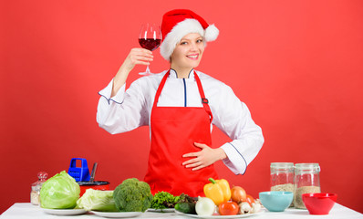 Enjoy easy ideas for holiday parties and holiday dinners. Festive menu concept. Christmas dinner ideas. Christmas menu. Woman chef cooking wear santa hat drink wine. No stress. Best christmas recipes