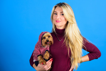 Which dog breeds should wear coats. Woman carry yorkshire terrier. Girl attractive blonde hug cute dog. Apparel and accessories. Pet supplies. Dressing your dog for cold weather. Dogs need clothes
