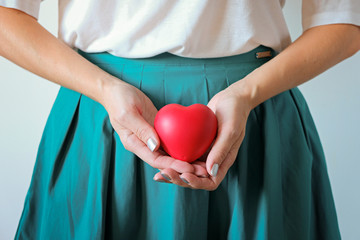 Woman healthcare, pregnancy and gynecology concept. A woman's hands holding a heart symbol on belly