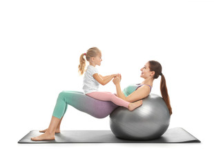 Obraz na płótnie Canvas Young woman and her daughter doing exercise isolated on white. Home fitness