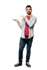 Full-length shot of Handsome man with beard holding copyspace imaginary on the palm to insert an ad over isolated white background