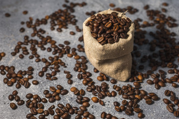 Fototapeta na wymiar coffee beans in a bag on gray stone background