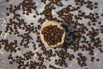 coffee beans in a bag on gray stone background