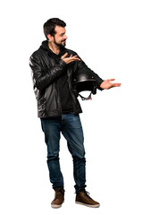 Full-length shot of Biker man extending hands to the side for inviting to come over isolated white background