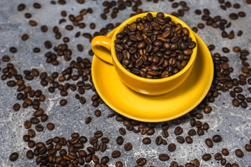 cup of coffee with beans on gray stone background