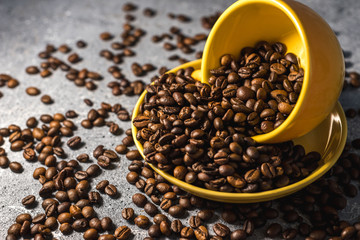 cup of coffee with beans on gray stone background