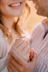 Close-up of a wedding ring in the hands of a happy couple. Love and relationship concept.