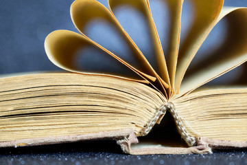 Opened old book with fairy tales or myths on a dark background. Library archive. History and...