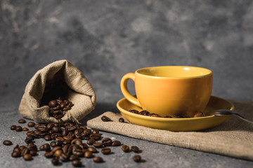 cup of coffee with beans on gray stone table