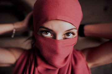 Beautiful Arabic woman in red hijab with bright makeup. Cappadocia. Turkey