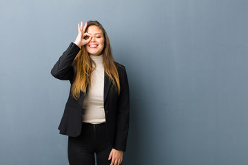 businesswoman smiling happily with funny face, joking and looking through peephole, spying on...